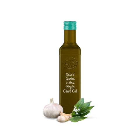 Bear's garlic extra virgin olive oil in a glass bottle with a teal cap, accompanied by fresh wild garlic leaves, flowers, and garlic bulbs.