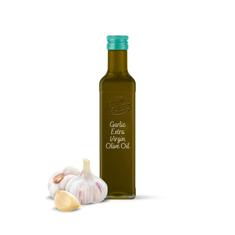 Extra virgin olive oil infused with garlic in a dark green bottle with a teal cap, featuring a labeled front, next to fresh garlic bulbs.