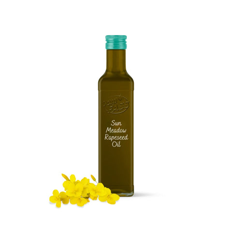 Rapeseed oil in a dark glass bottle with a teal cap, labeled "Sun Meadow Rapeseed Oil," placed next to bright yellow rapeseed flowers.